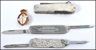 A group of vintage pen knives to include a rococo influence sterling silver example, a believed
