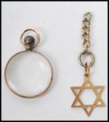 A 9ct gold Star of David together with a miniature gold metal  ( untested ) pendant in the form of a