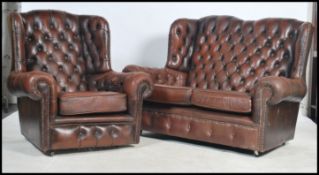 An antique style brown leather Chesterfield sofa settee having buttoned back leather scrolled arms