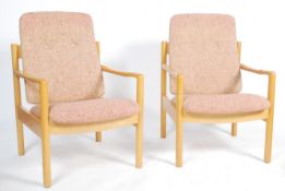 A pair of 20th century Ercol staff chairs. Light beech wood turned construction with shaped elbow