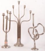 A group of three retro 20th century candelabra / table centres being fabricated from stainless steel