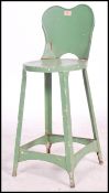 An early 20th century Industrial metal machinists stool / chair. Painted green with peripheral