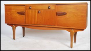 A good 1970's retro inverted teak wood sideboard dresser raised on tapering legs with inverted bow
