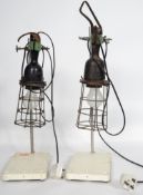A pair of mid century industrial trouble inspection cage lamps being reverse mounted to scientific
