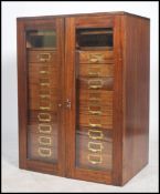 A good mid century mahogany Industrial office filing cabinet being housed behind twin glass doors