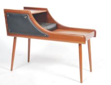 A good 1970's retro teak wood telephone - side table being raised on tapering turned legs with black