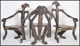 A set of 20th century African / Indonesian carved and ebonised elbow chairs comprising of a flat