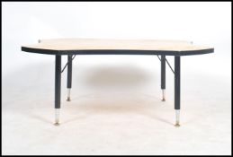 A rare 1950's large yellow formica palette shaped coffee table / occasional table being raised on