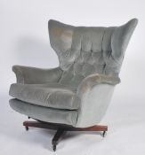 An original 1960's believed Parker Knoll black Batwing swivel chair - armchair being raised on