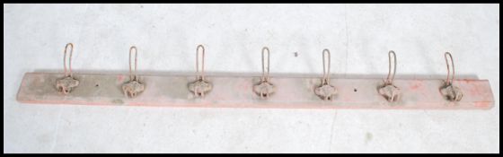 A set of seven vintage mounted early 20th century coat hooks each having an individual cast number