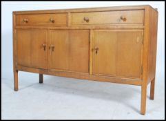 A Heal`s mid century oak sideboard, two long drawers (with Heal & Sons roundel to top drawer)