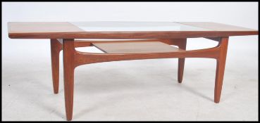 A retro 1970's teak wood G Plan long John coffee table with drop in glass top with exposed slated