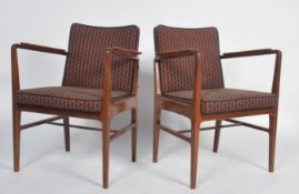 A pair of mid century Danish inspired teak wood armchairs. Each raised on tapering legs with