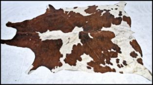 A vintage retro 20th century Argentinian two tone cow hide floor rug. Measures: 250cm long x 130cm