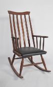 A rare 1960's Danish teak wood rocking chair being raised on turned supports with sleigh runners