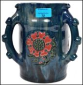 An Elton ware three handled loving jug having tube