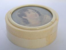 An early 19th century Georgian ivory powder box of circular form with a inset painting on ivory of a