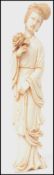 A 19th century Oriental ivory figurine carving of a Geisha in robes holding a large flower.