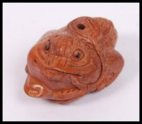 An unusual Oriental wooden carving netsuke in the form of a toad.