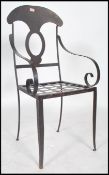 A vintage 20th century painted metal chair having scrolled arm rests with pierced back and seat