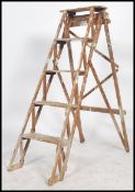 An early 20th century Lattice side wooden Industrial pine wood step ladder. Of A-frame shape