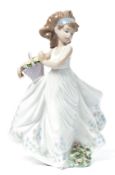 A Lladro ceramic figure of a girl holding a basket of flowers entitled floral path. Impressed