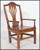 An 18th century North Country oak carver - hall chair having an arched op rail, pierced lyre