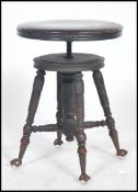Victorian revolving circular top ebonised piano stool on turned supports and H shaped under-