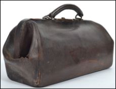 A vintage doctors leather gladstone bag dating from the 20th century together with a doctors medical