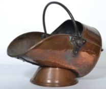A 19th century copper coal scuttle of traditional form with shaped lip and swing handle atop.