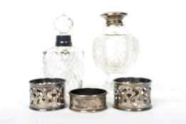 A group of silver hallmarked scent perfume bottles and napkin rings to include a pair of pierced