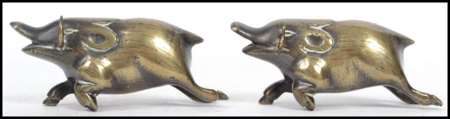 A pair of Oriental Chinese brass novelty figurines on the form of boars with horns. Measures: 3cm