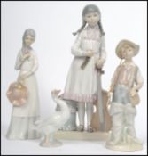 A group of three Lladro ceramic figures to include a Goose, boy with fishing rod and a girl with