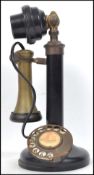 A vintage 20th century ring dial stick telephone having a brass earpiece with bakelite mouth piece