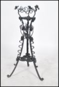 A stunning 20th century ebonised wrought iron scroll work planter / plant stand raised on tri-pod