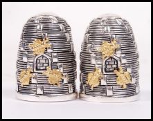 A pair of continental silver condiments in the form of bee hives with gilt silver bees being stamped