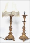 A pair of 20th century gilt bronze table lamps having a rococo design raised on a tripod base highly