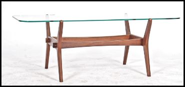 A retro mid century Danish inspired teak wood and glass coffee table being raised on cross shaped