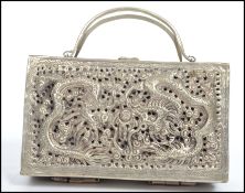 A Chinese silver ladies bag in the form of a box with handle and catch to top. Decorated to lid with