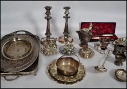 A large collection of silver plated wares to include a pair of large candlesticks, a 4 person egg