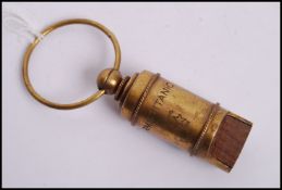 A vintage style reproduction RMS Titanic White Star Line brass whistle with bail hoop atop.