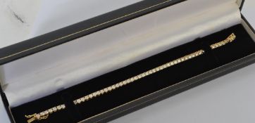 A hallmarked 14ct gold tennis bracelet set with round cut CZ. Import mark for London. Measures