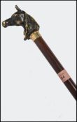 A vintage 20th century hunting / equestrian related walking stick cane having a tapered stem with