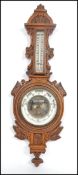 A Victorian oak carved aneroid barometer having an enamelled face and Fahrenheit gauge.Measures 64