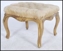 An early 20th century gilt plaster and wooden square footstool being raised on shaped legs with