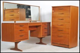 A 1970's teak wood dressing table chest Austin suite. The dressing table being raised on teak