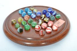 A Victorian solitaire set having a wooden circular board with various glass marbles.
