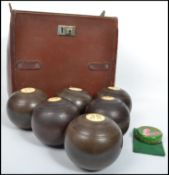 A good early 20th century set of Lignum wood bowls ( x 2 sets ) being within a good leather