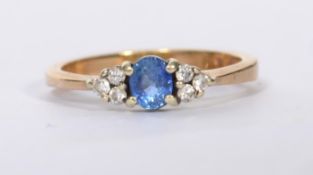 A hallmarked 9ct gold sapphire and diamond ring set with a central oval cut blue sapphire flanked by