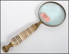 An early 20th century vintage handheld Magnifying glass being set with a turned Ivory handle ( see